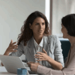 Two colleagues engaged in one-on-one conversation, reflecting healthy interpersonal dynamics and trust in a team setting